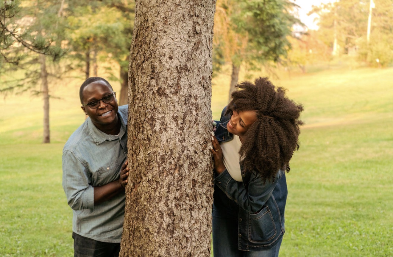 Lois and Peleg smiling together beside a tree